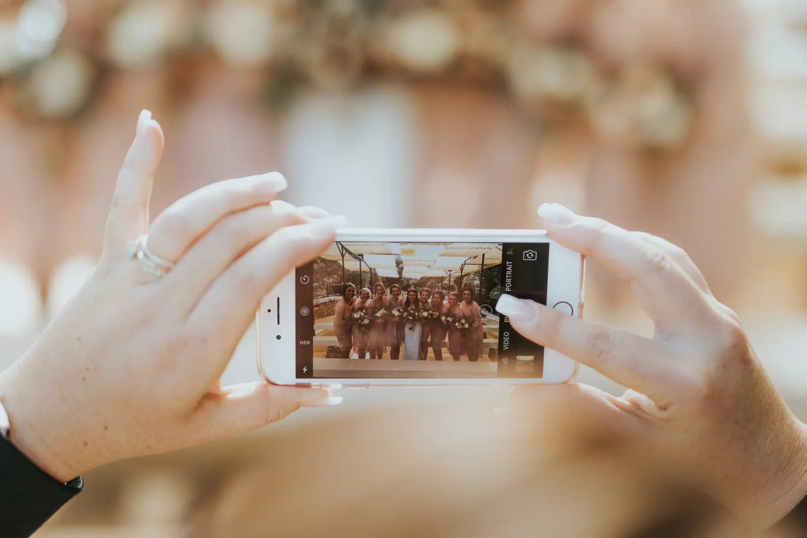 Gast fotografiert mit dem Smartphone eine Gruppe von Personen